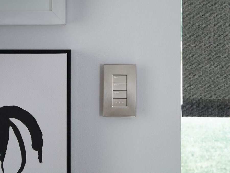 A Lutron wall keypad with motorized shades to the right of it.