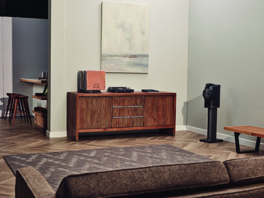 A modern living room with a turntable system and a B&W loudspeaker. 